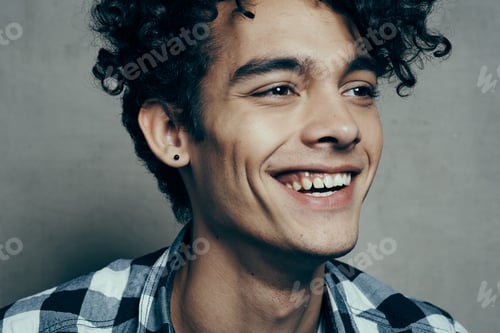 Preview: emotional guy in a plaid shirt on a gray background laughing confusion sadness uncertainty