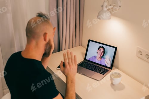 Preview: Man facetime at home, calling his friend wife girlfriend from laptop in bedroom.