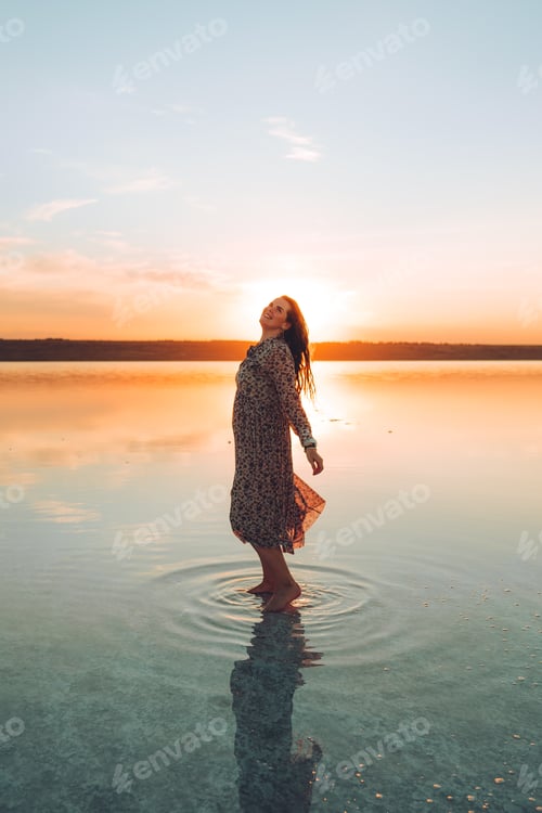 Preview: Woman Enjoying Sunset in Water, Ripples Reflecting Light