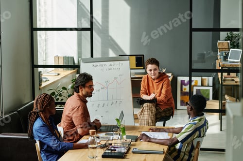Preview: Young businesswoman with partial arm sitting by whiteboard