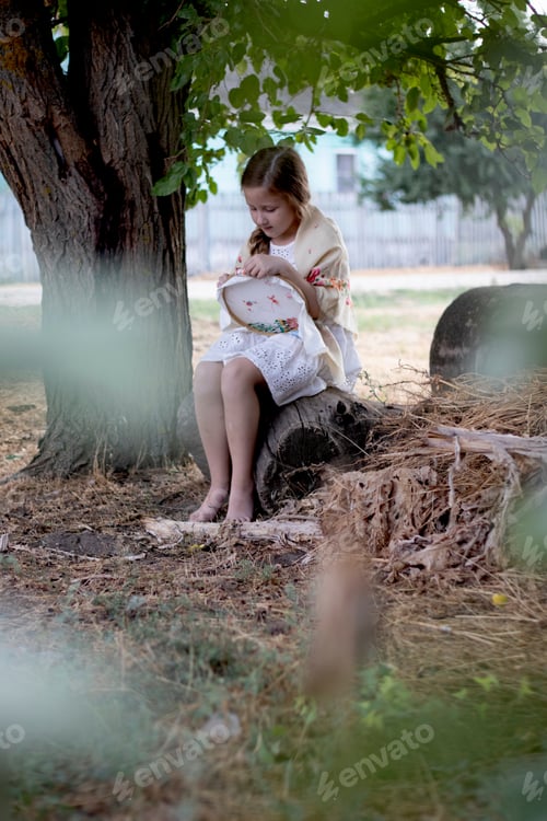 Preview: A girl embroiders with a cross