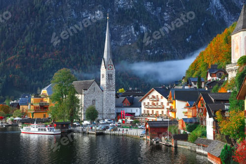 Preview: Foggy autumnal sunrise at famous Hallstatt lakeside town reflect