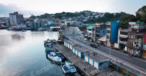 Preview: Fishing boats at Zhengbin Fishing Harbor in Taiwan with buildings and road at dusk