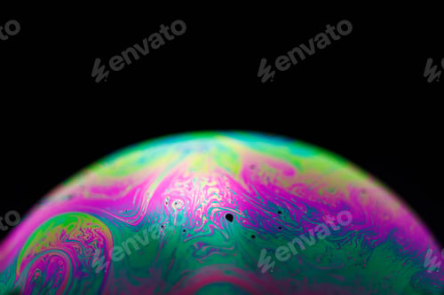 Preview: Rainbow soap bubble on a black background. Close-up of a colorful surface.