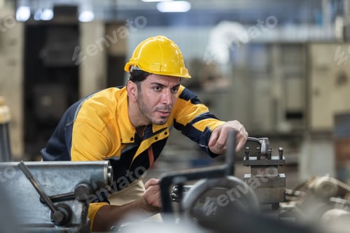 Preview: Caucasian man engineering workers wear yellow hard hat working machine lathe metal in factory