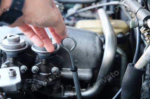 Preview: Image of a car mechanic checking the oil engine level.