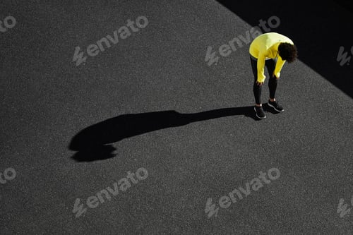 Preview: Tired man after cardio workout. Running man taking a break after run under the sun. Fitness athlete