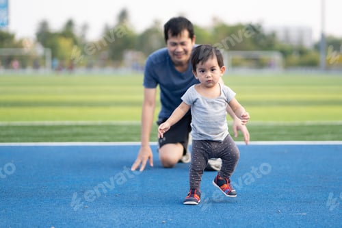 Preview: A cute little baby boy is learning to walk for his first step and daddy help to support the child