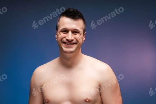 Preview: Happy man smiling posing showing torso on blue background