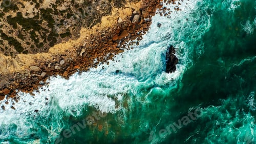 Preview: Drone view over sea water surface the rocky shore. Top view over ocean waves to the rocky shore.