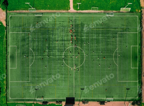Preview: Aerial drone view of sport fields or sports stadium with players running on green grass in Finland