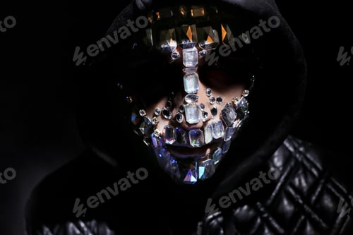 Preview: Art portrait of a hooded man with big rhinestones on his face. Mysterious mystical appearance of a