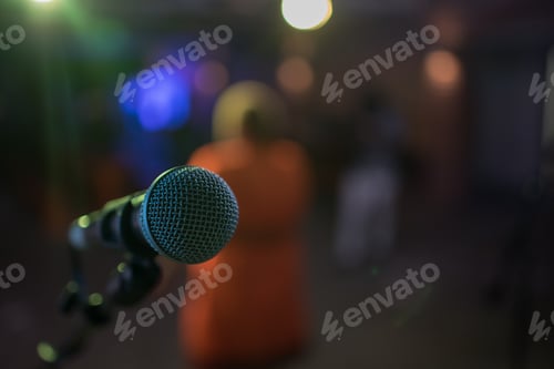 Preview: Selective focus on microphone with performer seen standing in foreground