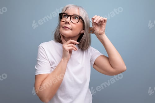Preview: middle age business. smart mature woman pensioner holds the keys to the purchased real estate on the