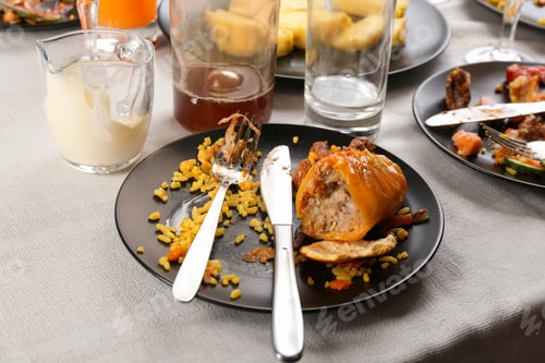 Preview: Food leftovers after party on table with cloth