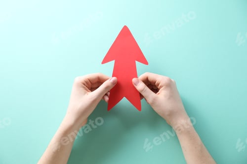 Preview: Woman with paper arrow on turquoise background, top view