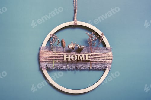Preview: Handmade home decor from a wooden circle and dried flowers with the inscription Home
