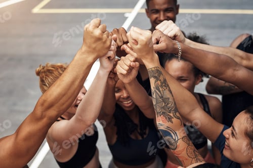 Preview: Shot of a group of sporty young people standing together in a huddle on a basketball court