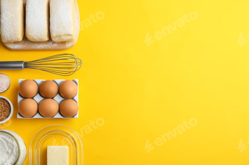 Preview: Puff pastry dough and ingredients on yellow background, flat lay. Space for text
