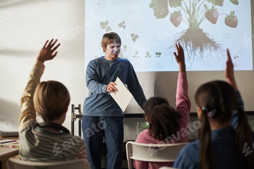 Preview: Teenage Caucasian Boy Teaching Diverse Children About Plant Biology in Classroom