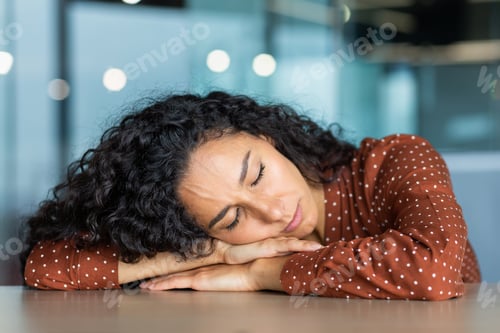 Preview: Beautiful tired hispanic woman sleeping on desk, close-up business woman with closed eyes napping