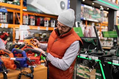 Preview: a man in a hardware store chooses a jigsaw