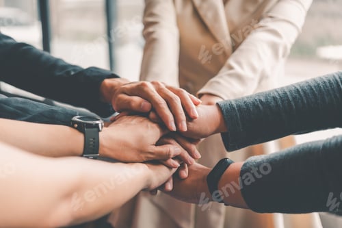 Preview: Hands of business people come together in a stack of hands to symbolize collaboration