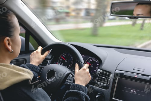 Preview: Woman driver's hands on a car steering wheel.