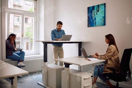 Preview: Group of young entrepreneurs using wireless technology while working in the office.
