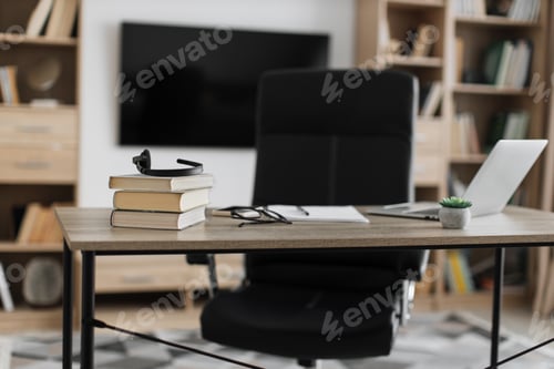 Preview: Shot of modern workplace, office with laptop, books, papers, eyeglasses, headset on wood table
