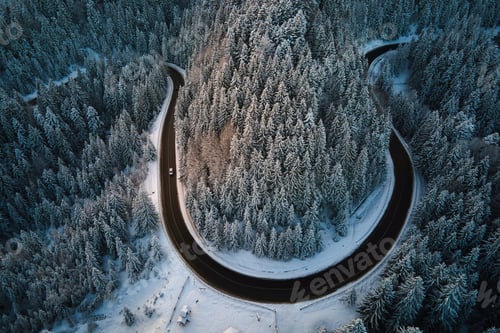 Preview: Aerial view of winter landscape with snow covered mountain hills and winding forest road in morning.
