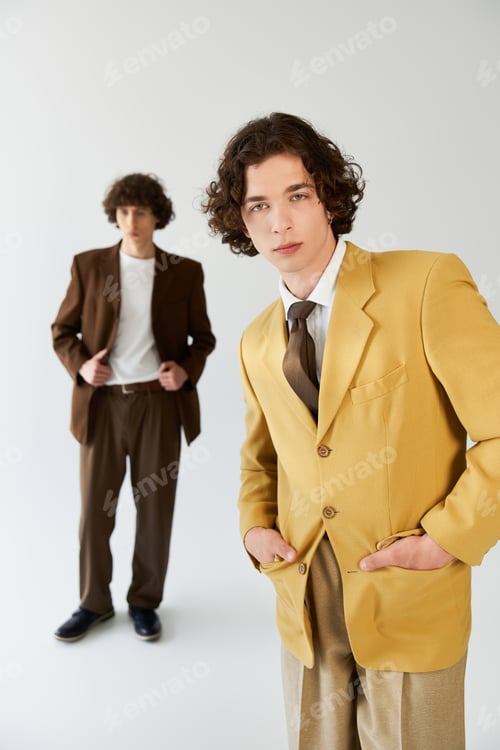 Preview: Young stylish friends showcasing modern fashion in a minimalist studio setting