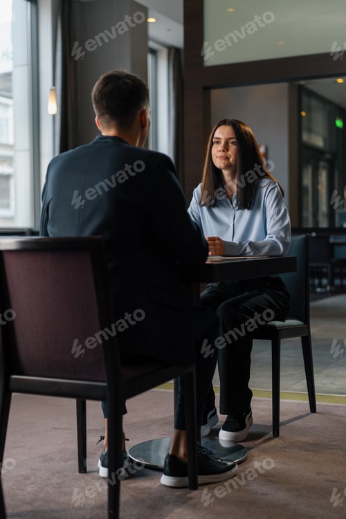 Preview: Business meeting in the restaurant of the hotel,colleagues discuss girl's face project