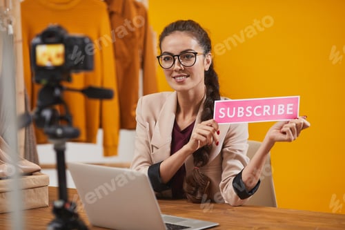 Preview: Smiling Young Woman Holding Subscribe Button