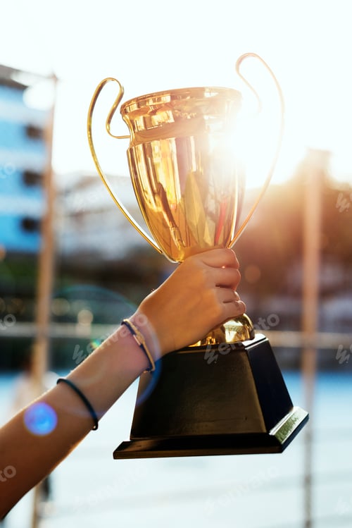 Preview: Feminine hand holding a trophy outdoors