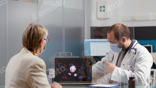 Preview: Health specialist showing virus illustration on laptop to old woman