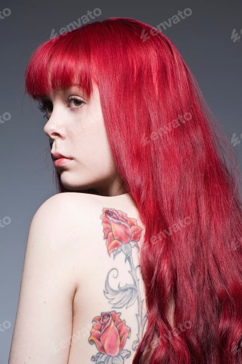 Preview: Young woman with long red hair and tattoo, studio shot