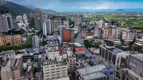 Preview: Urban landscape of Jiaoxi City Taiwan showcasing buildings green fields and cloudy skies