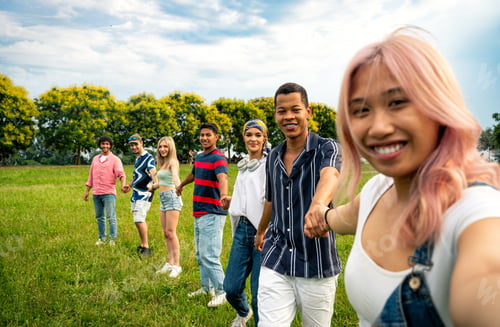 Preview: Group of multiethnic teenagers spending time outdoor on a picnic at the park