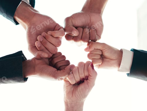 Preview: Low angle shot of a group of unrecognizable businesspeople joining their hands together in a unity