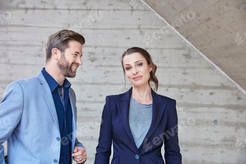 Preview: Smiling businessman looking at businesswoman