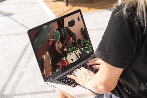 Preview: Man betting on sports using laptop at table, closeup. Bookmaker website on screen