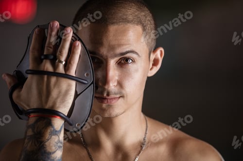 Preview: Handsome young man posing with swim paddle indoors