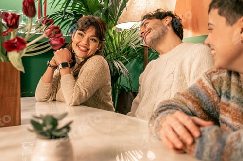 Preview: Happy woman in a candid moment, smiling with friends in a cozy bar or at home