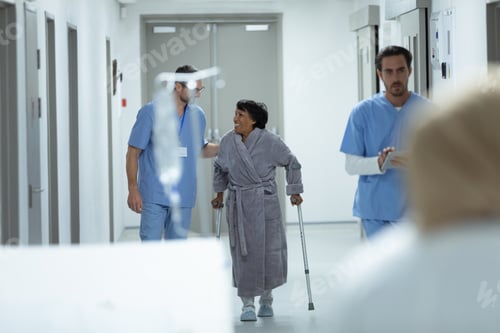 Preview: Caucasian male doctor interacting with disabled female patient in the corridor at hospital