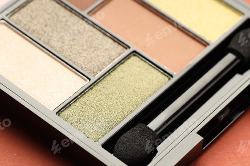 Preview: Beautiful eyeshadow palette and brush on coral background, closeup