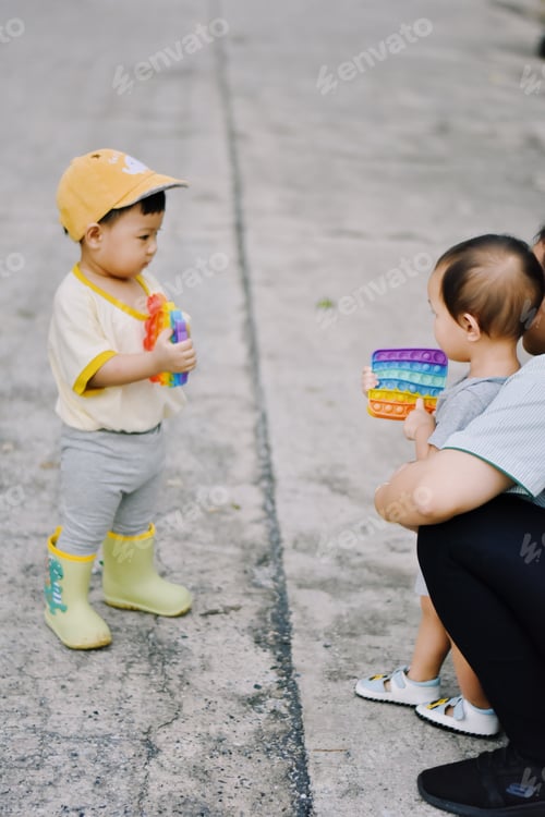 Preview: Toddlers Play with Toys on a Concrete Surface