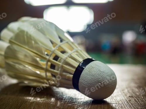 Preview: Closeup shot of White badminton shuttlecock on parquet floor.
