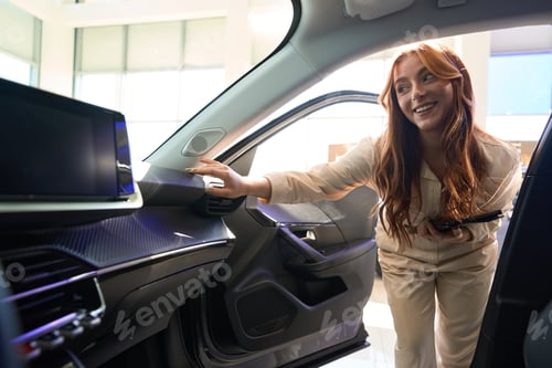Preview: Joyous sales consultant enjoying car interior quality