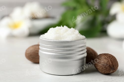 Preview: Shea butter in jar and nuts on white table, closeup